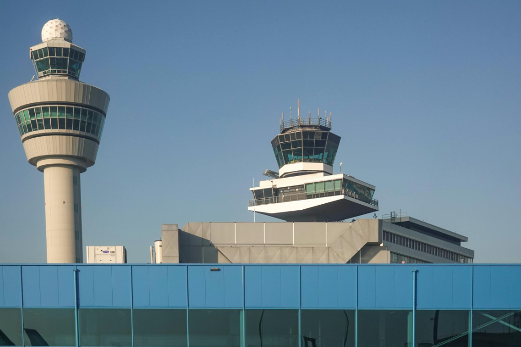 An air traffic control tower with a blue sky