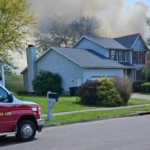 A grey house with smoke rising from the top