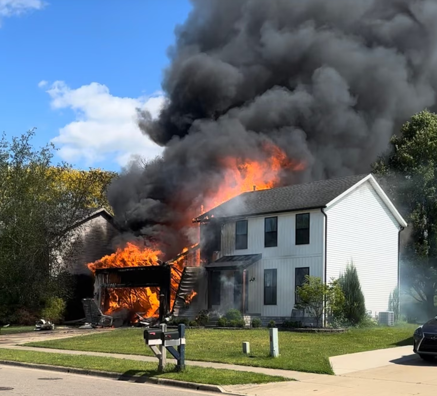 A white house burning with black smoke and fire