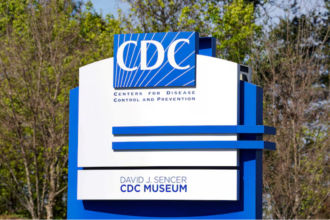A large blue and white sign for the Centres for Disease Control and Prevention, with trees in the background