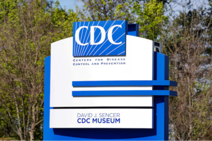 A large blue and white sign for the Centres for Disease Control and Prevention, with trees in the background
