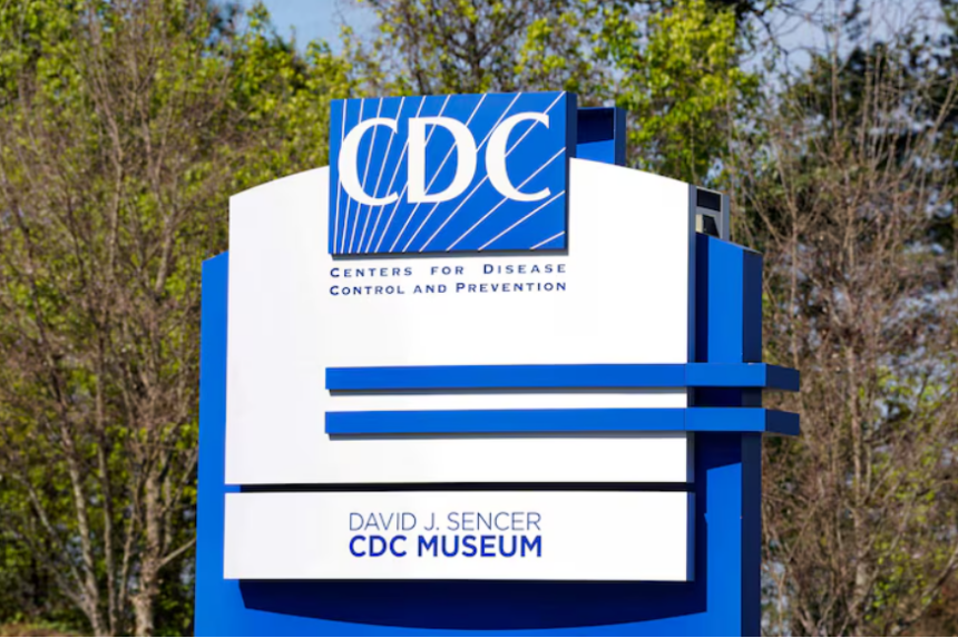 A large blue and white sign for the Centres for Disease Control and Prevention, with trees in the background