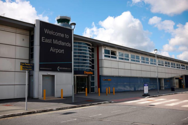 A grey and white building entrance with a large sign reading 'Welcome to East Midlands Airport'