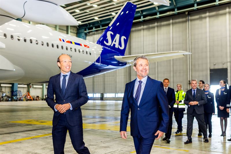 King Frederik X alongside SAS representative in an aircraft hanger with the new Airbus named after the King