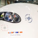 SAS Airbus A350 named ‘Frederik Viking’ during naming ceremony, with two men visible inside the cockpit waving from the aircraft window.