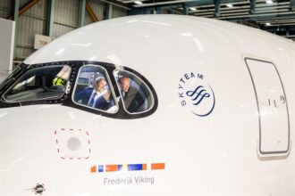 SAS Airbus A350 named ‘Frederik Viking’ during naming ceremony, with two men visible inside the cockpit waving from the aircraft window.