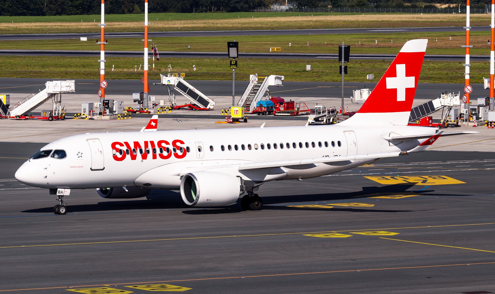 Swiss International Air Lines Airbus A220-100 HB-JBA "Kanton Zürich" taxiing at the airport, photographed from an elevated position showing the aircraft in standard white livery.