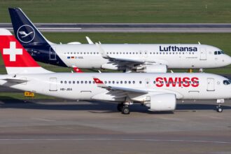 Swiss International Air Lines Airbus A220-100 HB-JBA taxiing past a Lufthansa Airbus A320-200 D-AIUL on an adjacent taxiway.