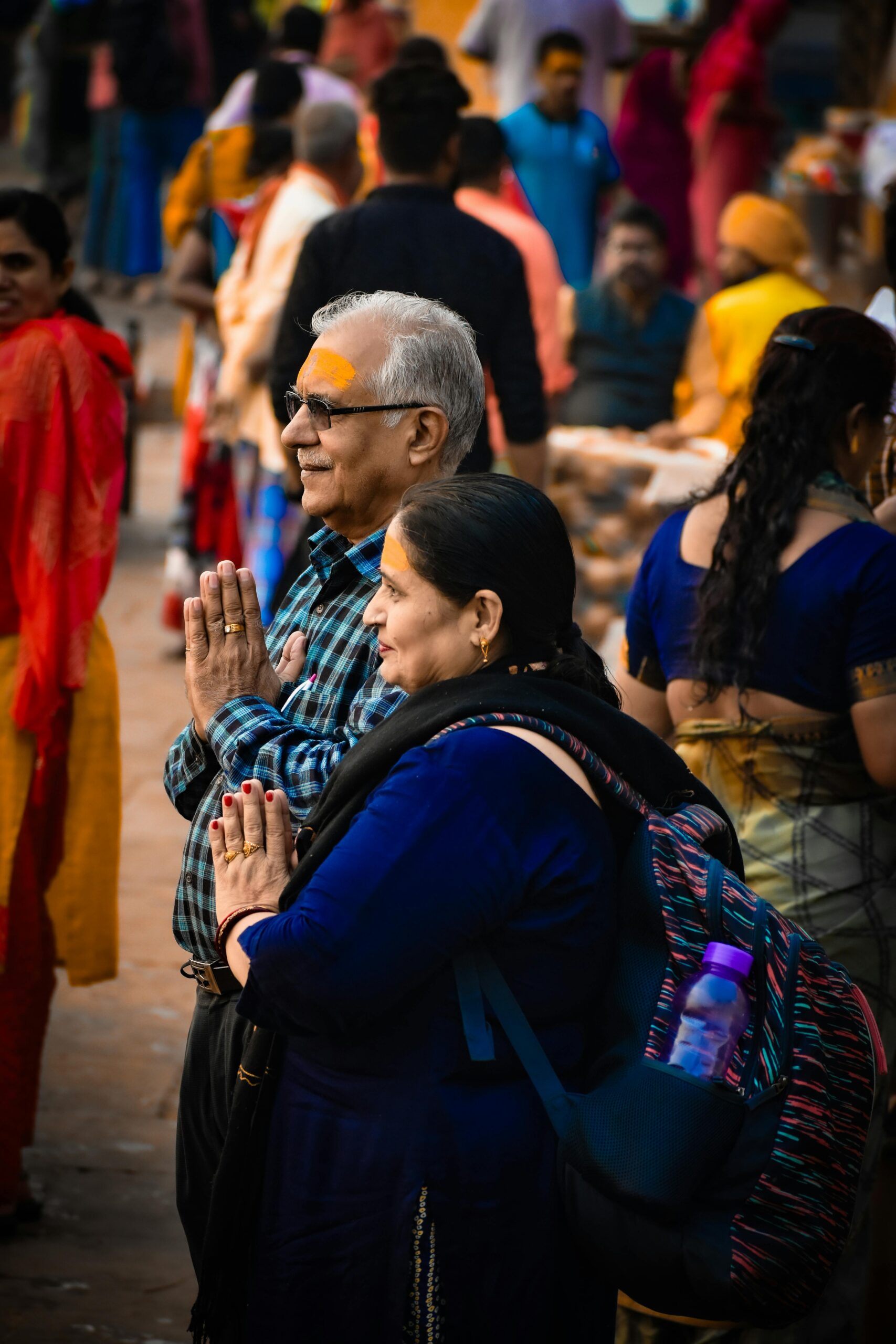 A diverse group of people engaged in prayer during an outdoor ceremony.