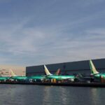 Planes lined up at airport in front of water
