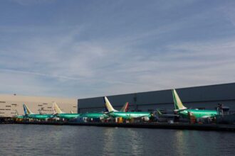 Planes lined up at airport in front of water