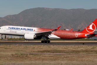 Turkish Airlines Airbus A350 TC-LHH in special 500th aircraft livery taxiing on runway with mountains in the background.