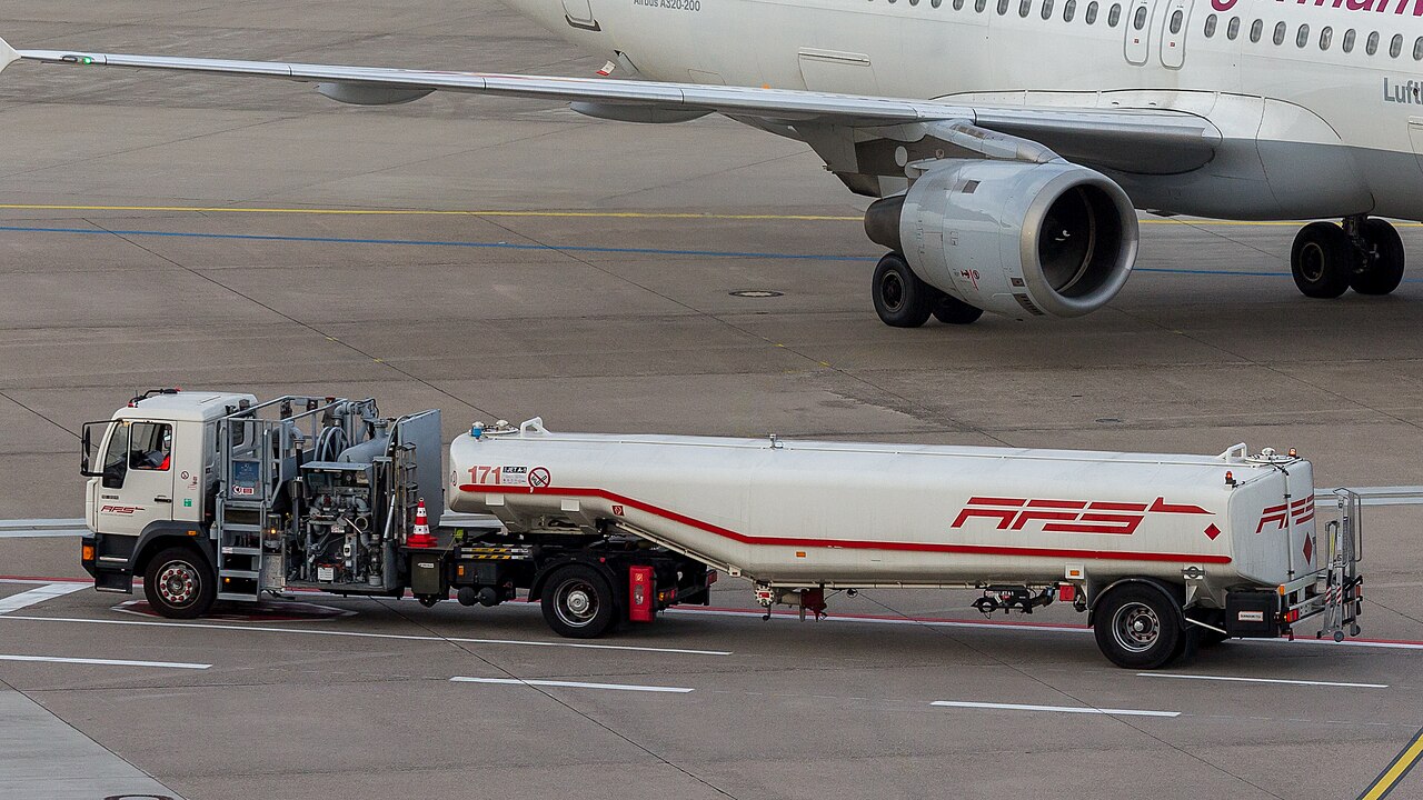 Airport tank truck full of Aviation Fuel Services (AFS) on the tarmac at Bonn airport, with an airbus close by in the background.