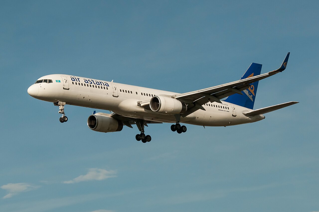 Air Astana Boeing 757 flying against a blue, largely cloudless sky.