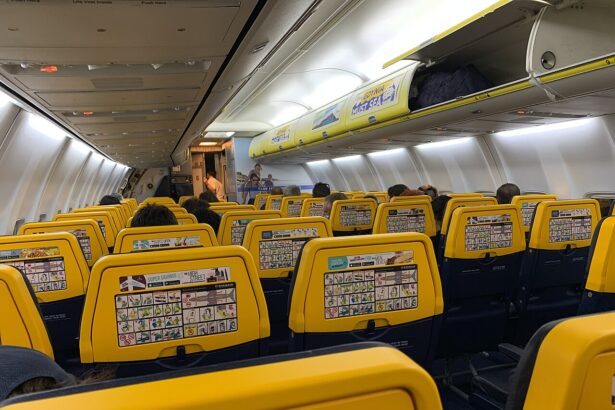 Interior of Ryain 737, with rows of yellow seat visible overhead light and cabin bag storage.