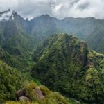 View from the valley Balcões, São Roque do Faial, Santana, Madeira. The sky is very cloudy and the view is filled with mountains covered in trees.