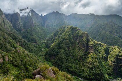 View from the valley Balcões, São Roque do Faial, Santana, Madeira. The sky is very cloudy and the view is filled with mountains covered in trees.