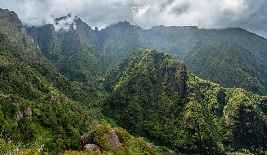 View from the valley Balcões, São Roque do Faial, Santana, Madeira. The sky is very cloudy and the view is filled with mountains covered in trees.