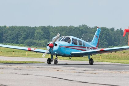 Image shows a small blue aircraft (Piper PA-28-151 Cherokee Warrior N405DS) grounded at Delaware Airpark during the day.