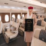 Flight attendant holding APEX award onboard an aircraft.