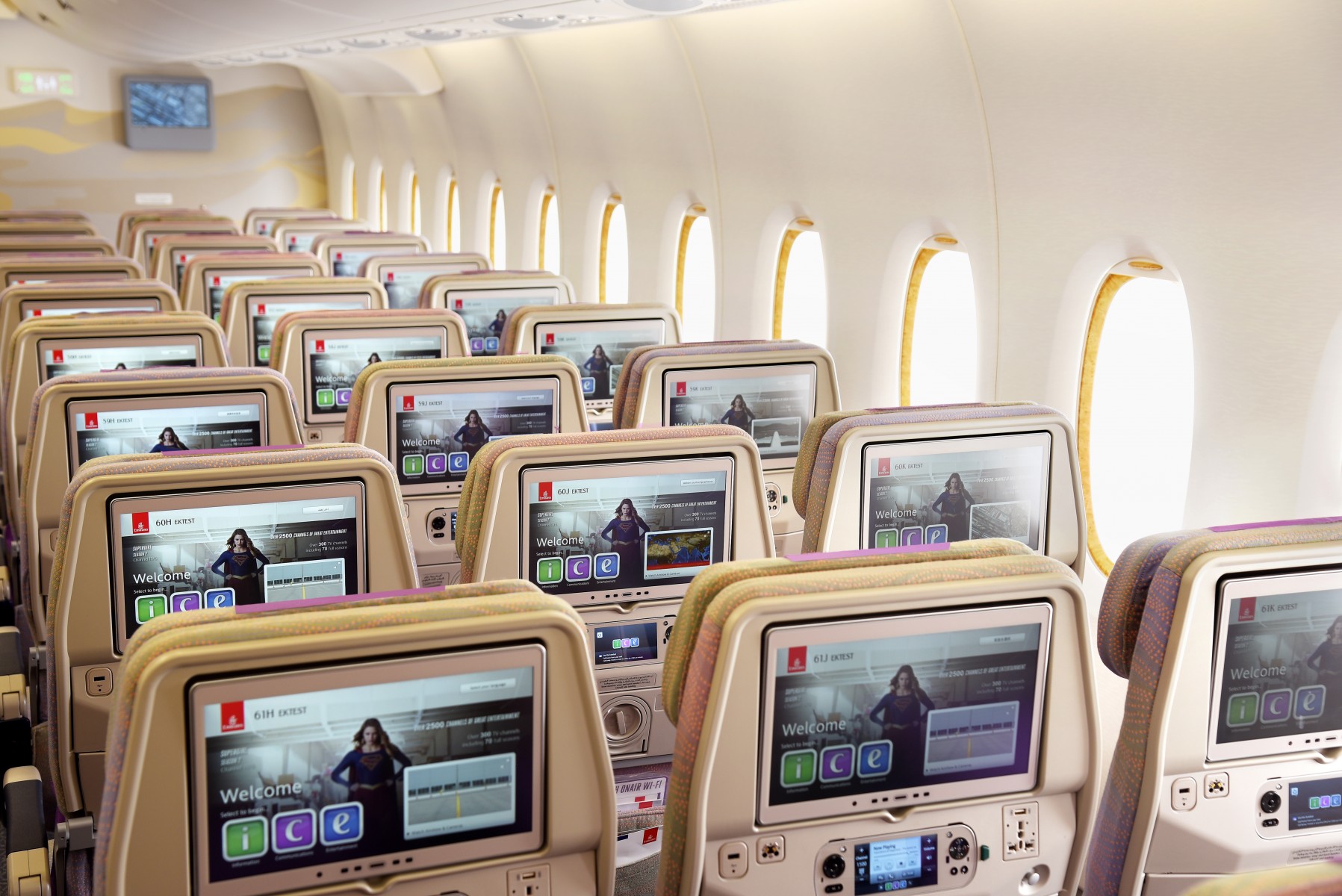 Emirates economy class three seat row with screens showing ICE entertainment system
