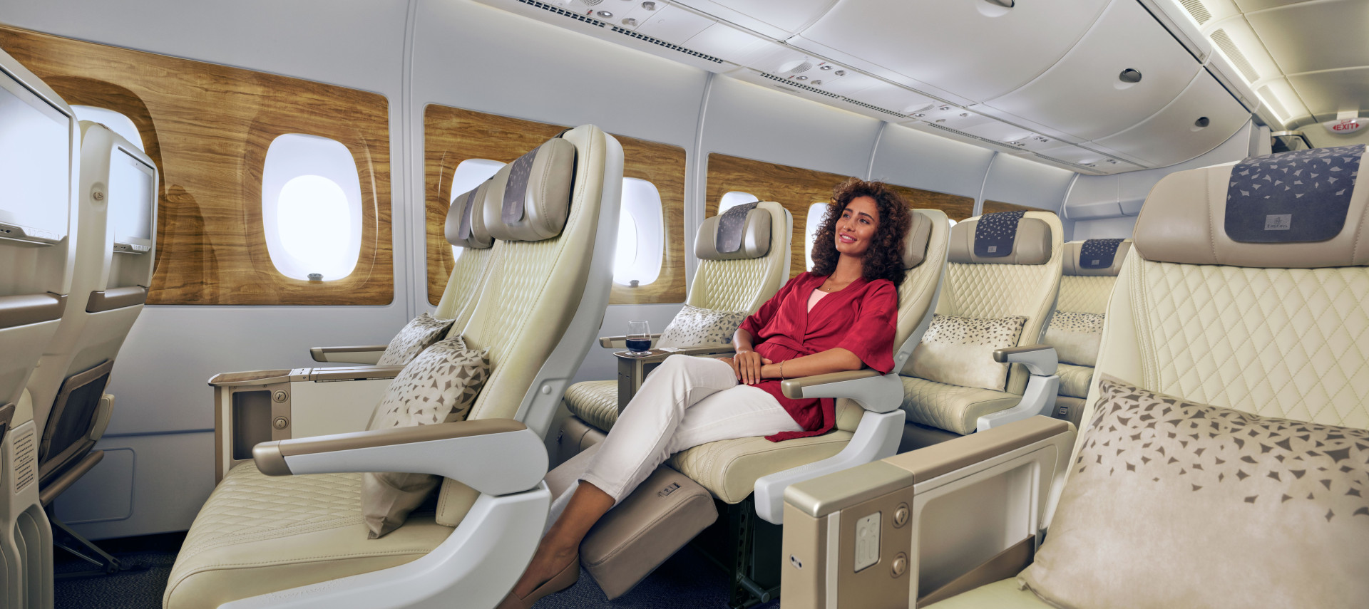 A lady sat in Emirates premium economy seat looking relaxed and comfortable.