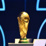 FIFA World Cup trophy on a stand with a blue back drop.