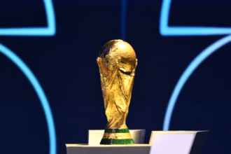FIFA World Cup trophy on a stand with a blue back drop.