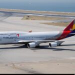 Asiana Airlines Boeing 747 sitting on a runway with the sea in the background