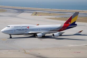 Asiana Airlines Boeing 747 sitting on a runway with the sea in the background