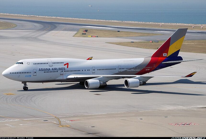 Asiana Airlines Boeing 747 sitting on a runway with the sea in the background