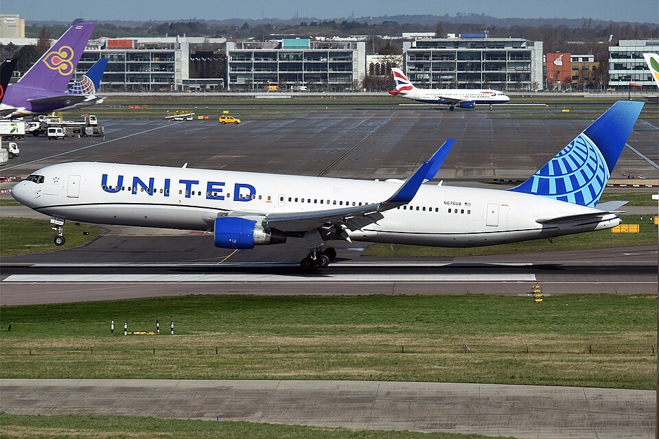 An eye-level, side-view photograph captures a United Airlines Boeing 767-300ER wide-body passenger jet.