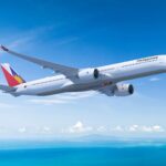 Philippine Airlines Airbus A350-1000 in flight against a blue sky.