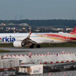 An Arkia Airbus A321 aircraft on the runway before takeoff. Blurry foreground and background.