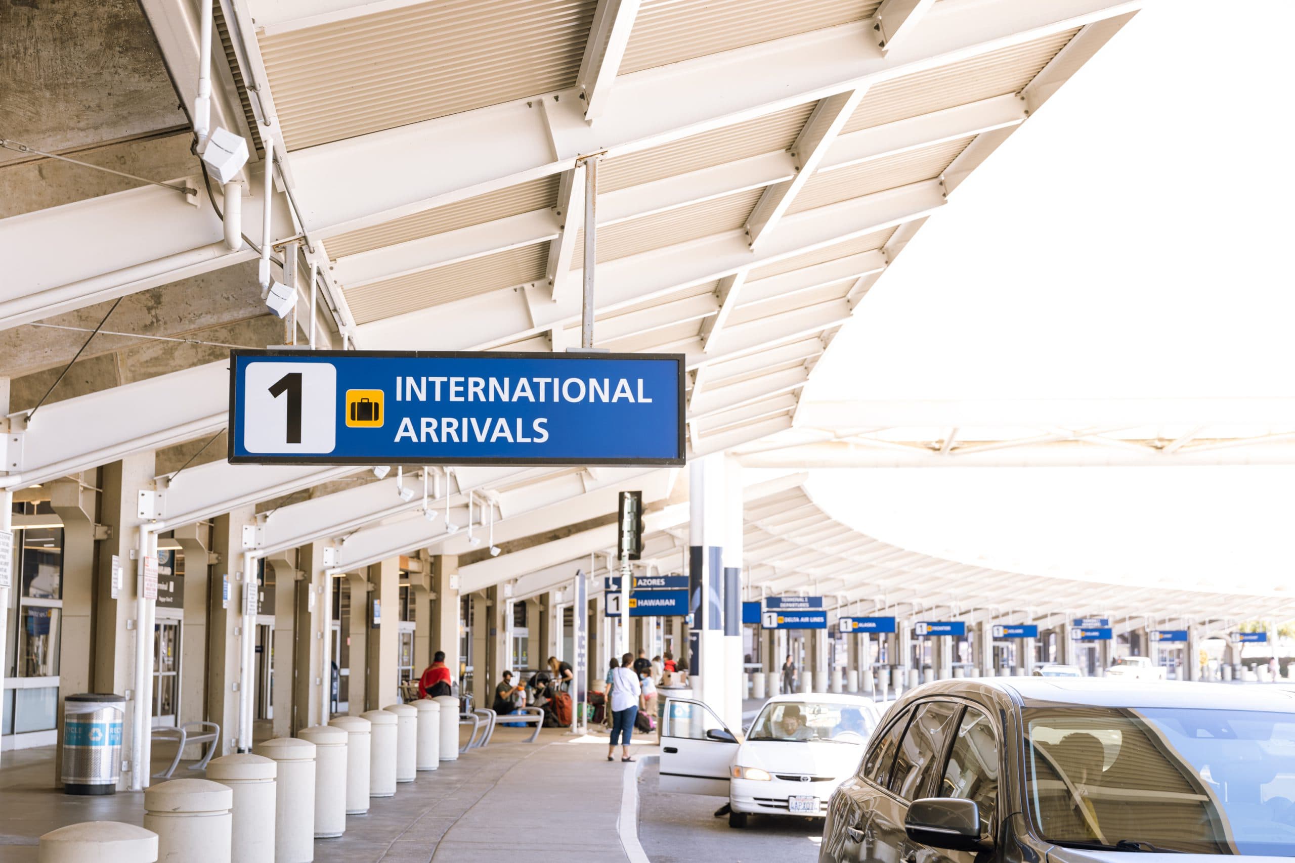 OAK Airport international arrivals terminal sign with cars parked outside