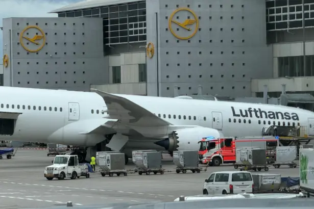 A Lufthansa Boeing 787-9 Dreamliner resting on its nose at Frankfurt Airport after a landing gear collapse with the aircraft positioned in front of a terminal building