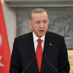 A close-up image of Turkish President Recep Tayyip Erdogan speaking at a conference in Athens, Greece