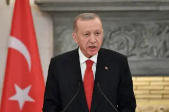A close-up image of Turkish President Recep Tayyip Erdogan speaking at a conference in Athens, Greece