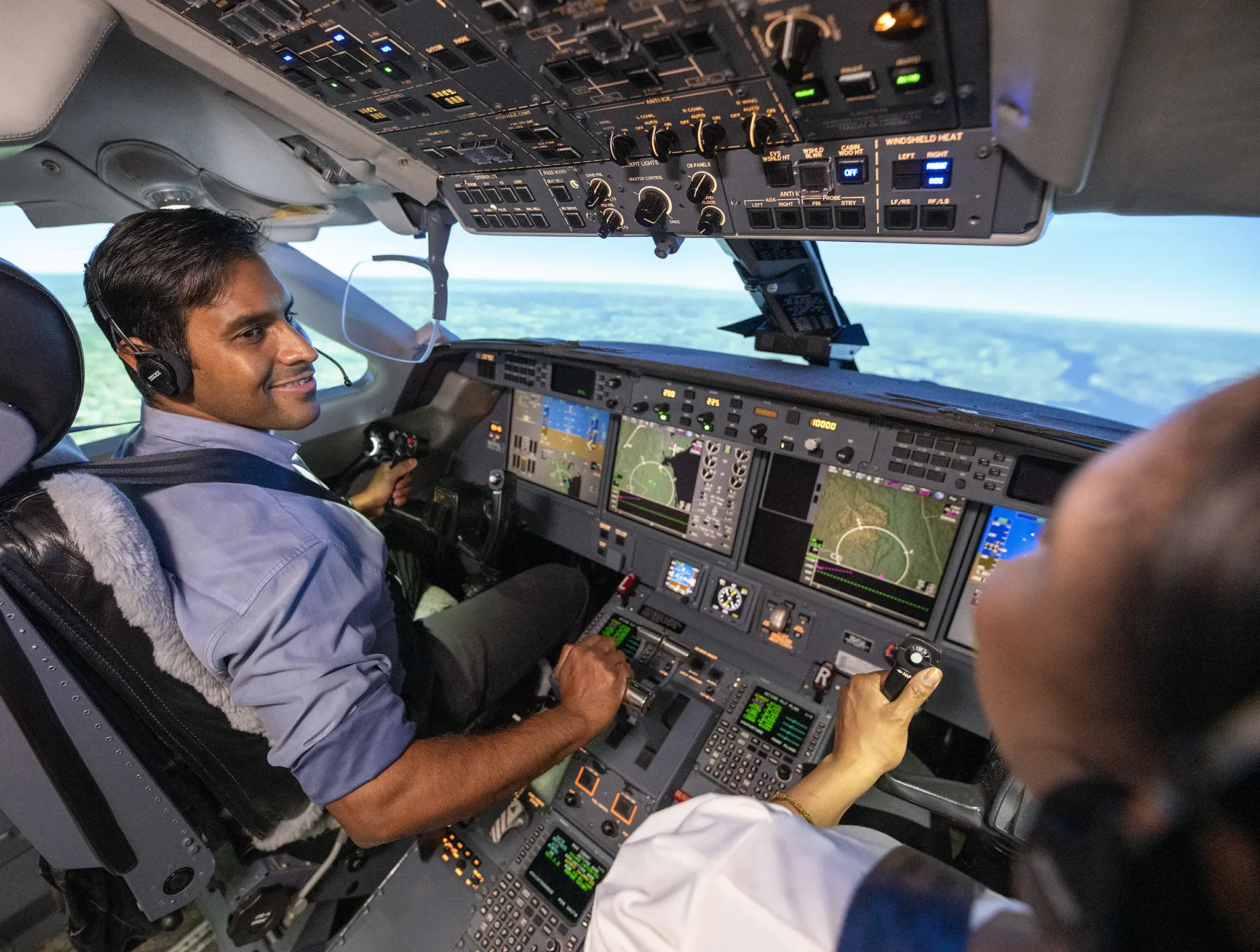 Two pilots in a plane’s cockpit, seen performing a training exercise.