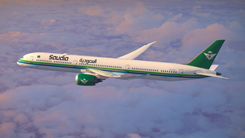 A Saudia Airlines jet in front of a cloudy sky.