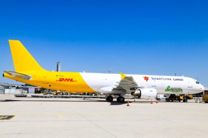 A DHL branded SmartLynx jet sat on a runway on a sunny day.