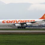 A Conviasa Airbus A340-200 jet on a runway in front of a green field.
