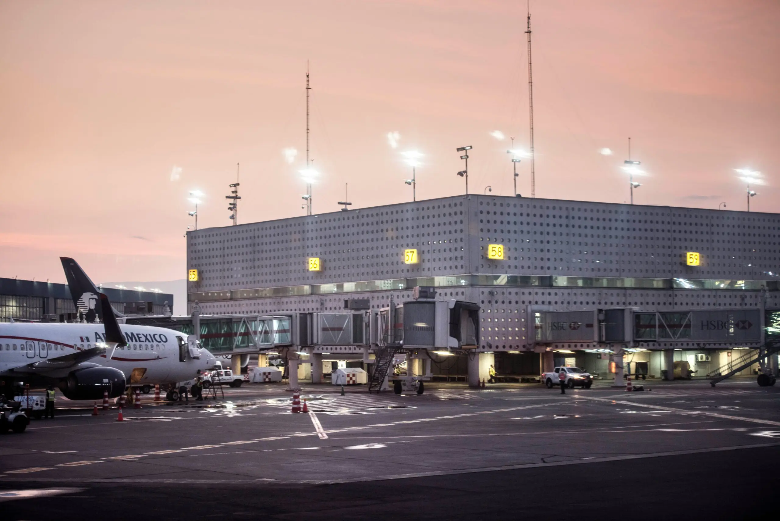 A sunset over Mexico City International Airport (MEX), showing a terminal building and an Aeroméxico jet.