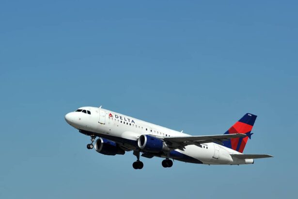 A Delta Air Lines Airbus A319 flying upwards in front of a clear blue sky.