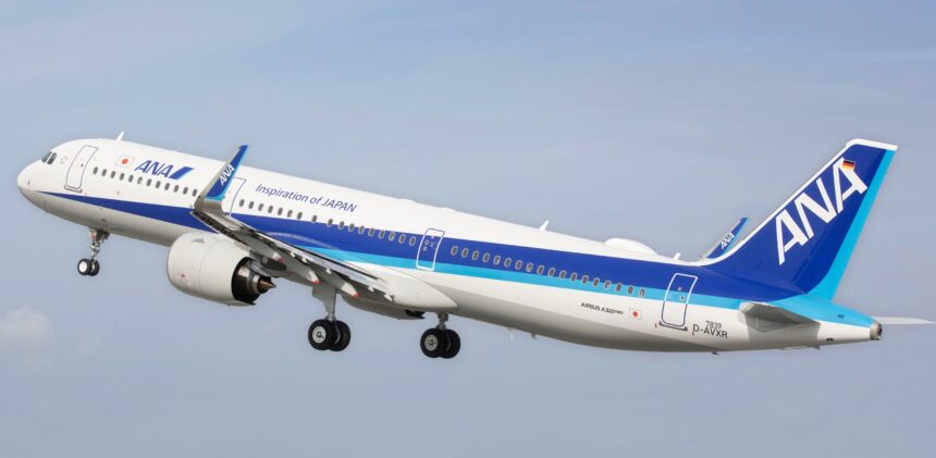 An Airbus jet from All Nippon Airways flying upwards in front of a clear blue sky.