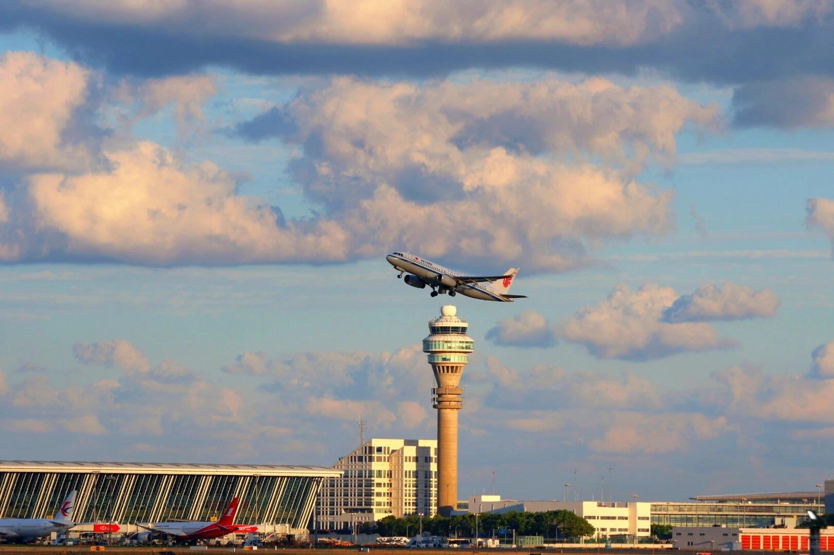 An Air China plane ascends over Shanghai Pudong International Airport (PVG).