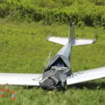 A small aircraft crash in an open field. The cockpit crushed, no smoke.