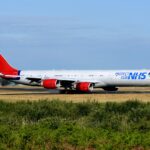 A European Cargo aircraft in NHS-branded livery taxis on a runway at an airport in the United Kingdom. The aircraft was used to transport personal protective equipment and COVID-19 test kits during the pandemic.