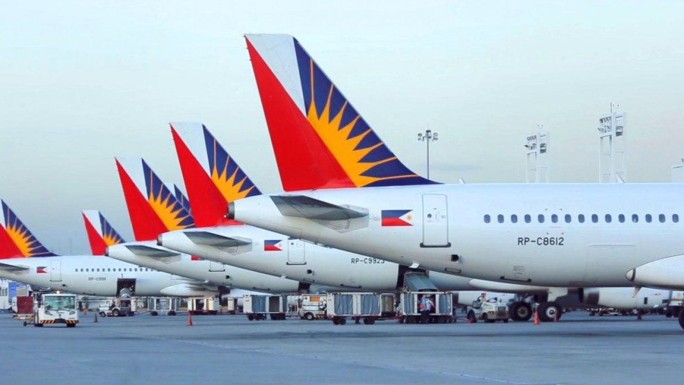 Tails of Philippine Airlines aircraft shown lined up on the tarmac.
