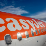 A close up of the side of an orange and white EasyJet airplane